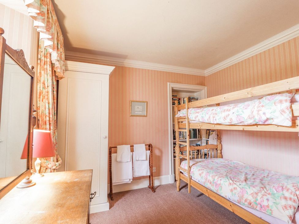 A bedroom with a bunk bed and a mirror at Druidaig Lodge in Kyle