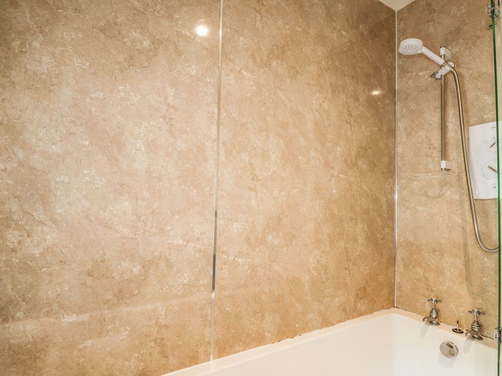 A bathtub with shower features at Druidaig Lodge in Kyle