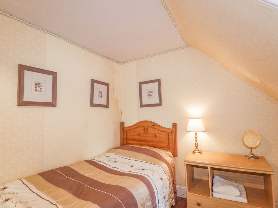 A bedroom with a bed and nightstand at Druidaig Lodge in Kyle