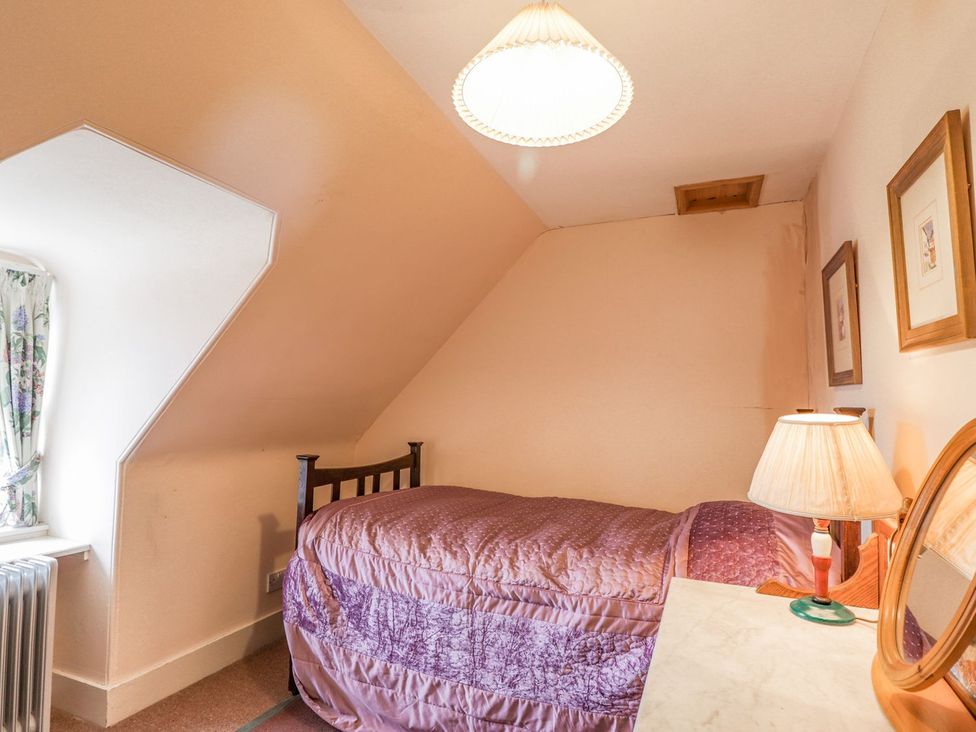 A bedroom with a bed and lamp at Druidaig Lodge in Kyle