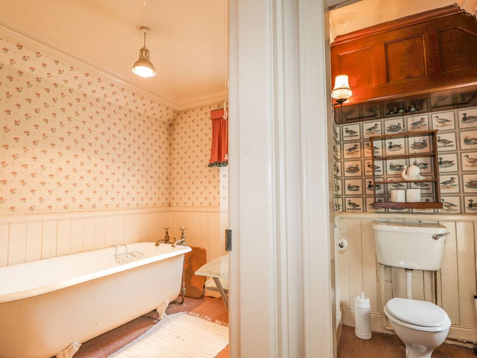 A bathroom with a bathtub and toilet at Druidaig Lodge in Kyle