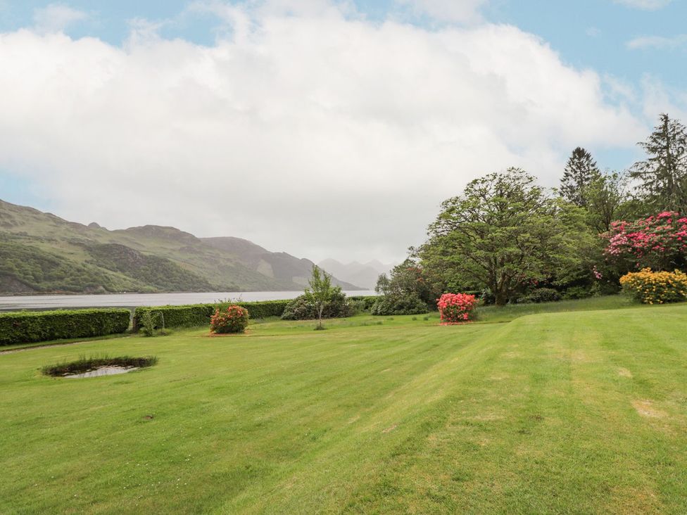 A garden with trees and water at Druidaig Lodge Kyle
