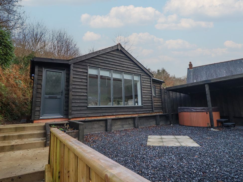 A cabin with large windows and a hot tub outside at Lodge at Nadur in 
