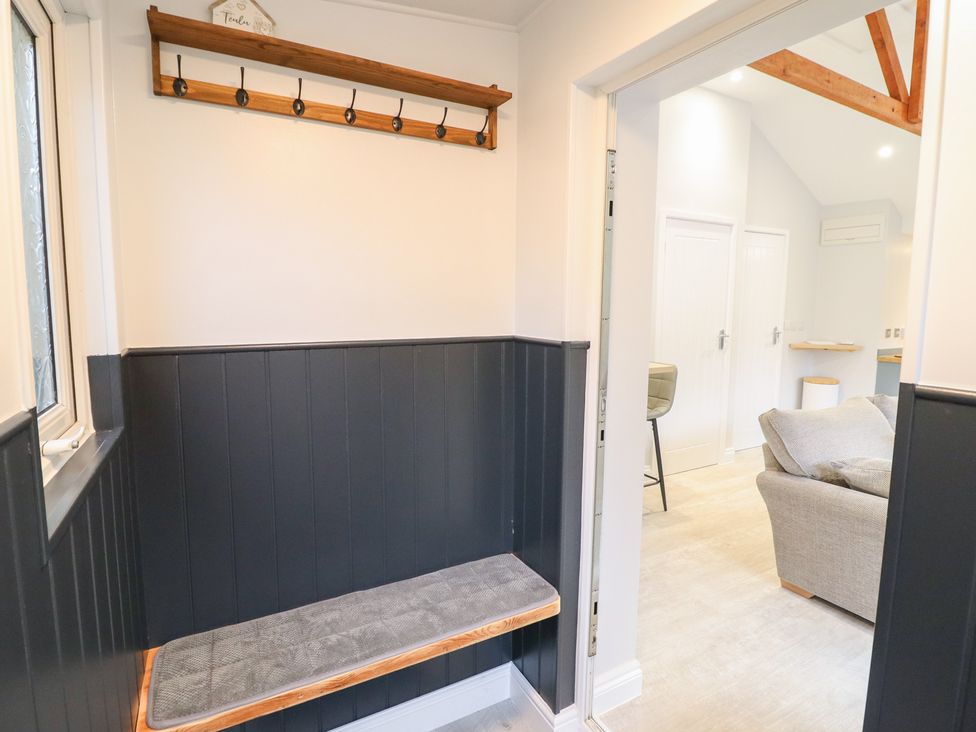 A hallway with a coat rack and bench at Lodge at Nadur