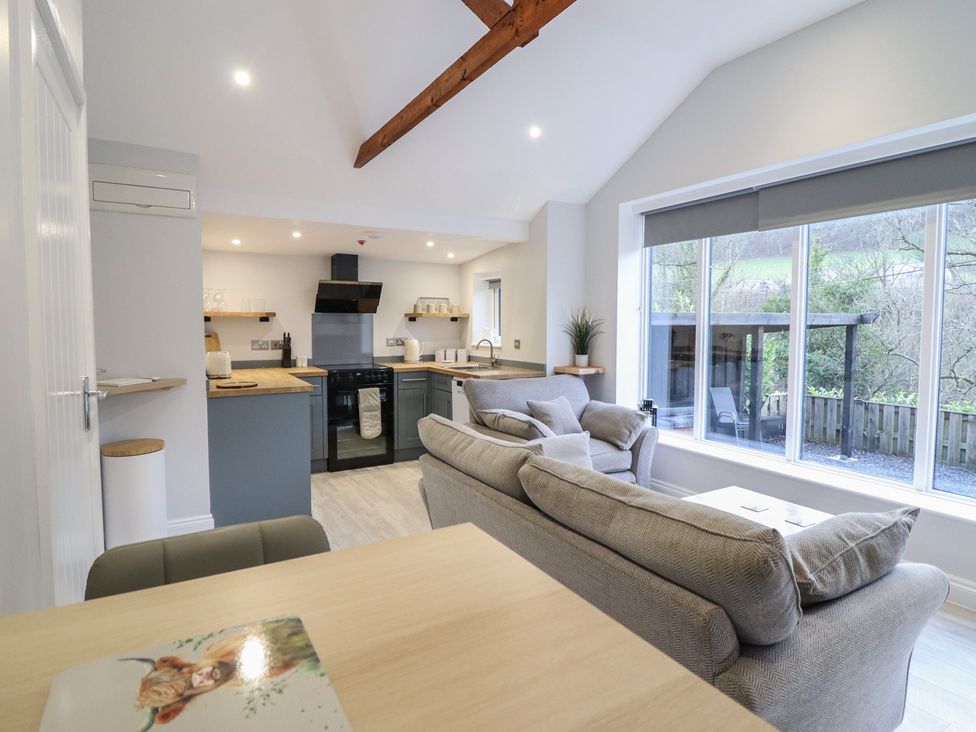 A living room with a sofa and kitchen area at Lodge at Nadur