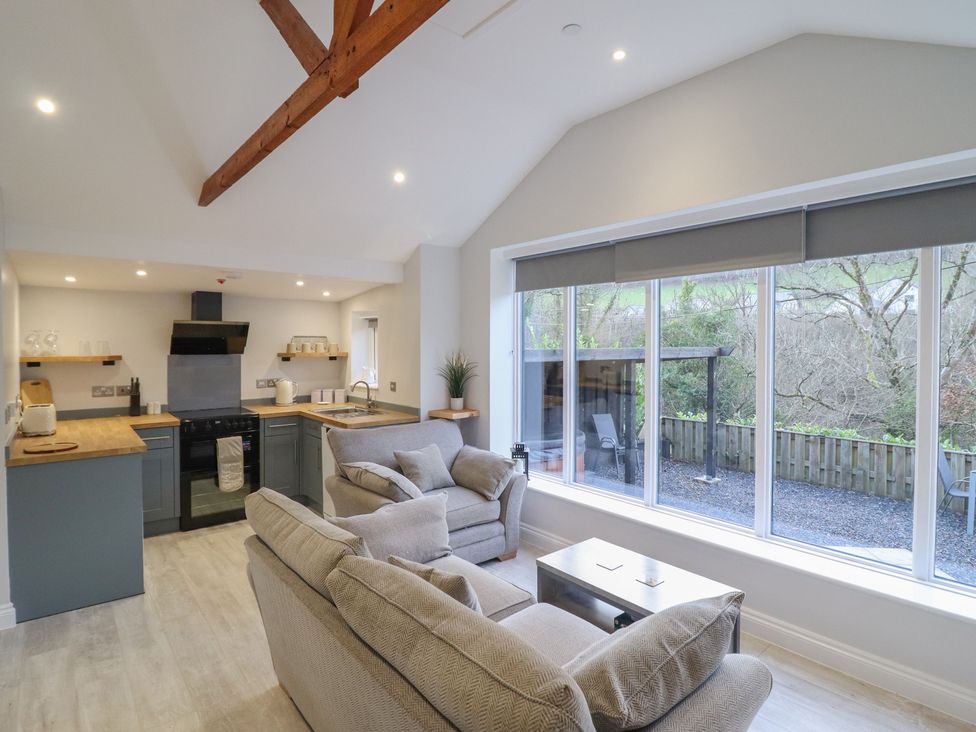 A living room with a kitchen area and large windows at Lodge at Nadur