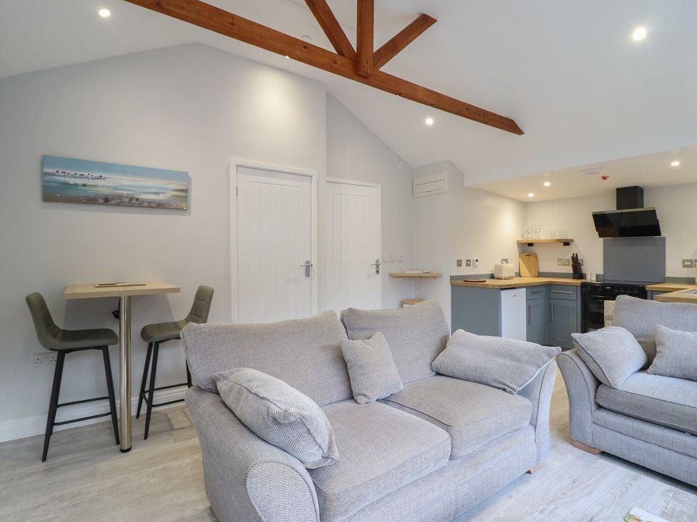A living room with a sofa and kitchen area at Lodge at Nadur in 