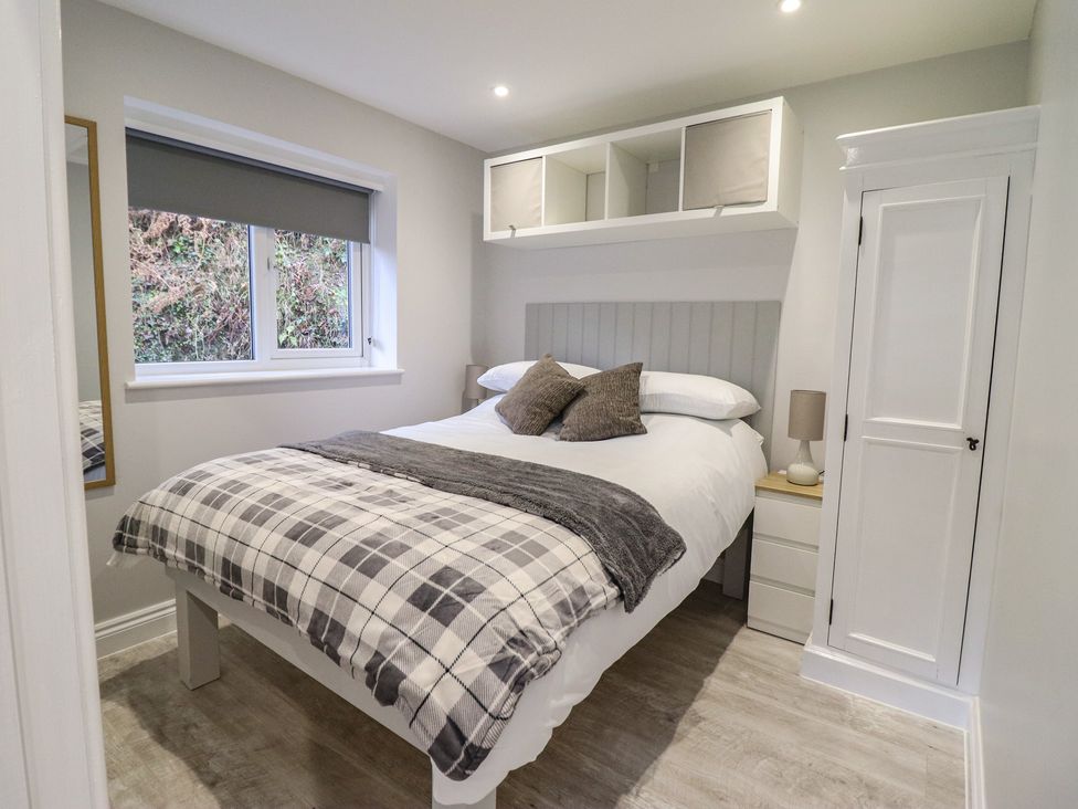 A bedroom with a bed and mirror at Lodge at Nadur