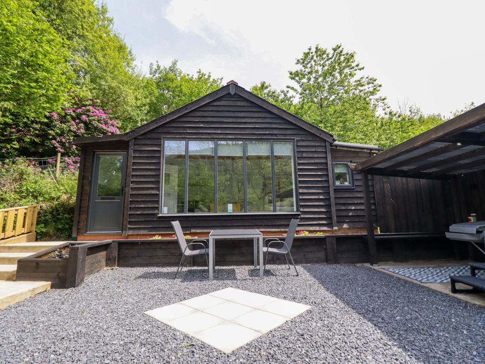 An outdoor area with a table and chairs at Lodge at Nadur Commins Coch near Machynlleth
