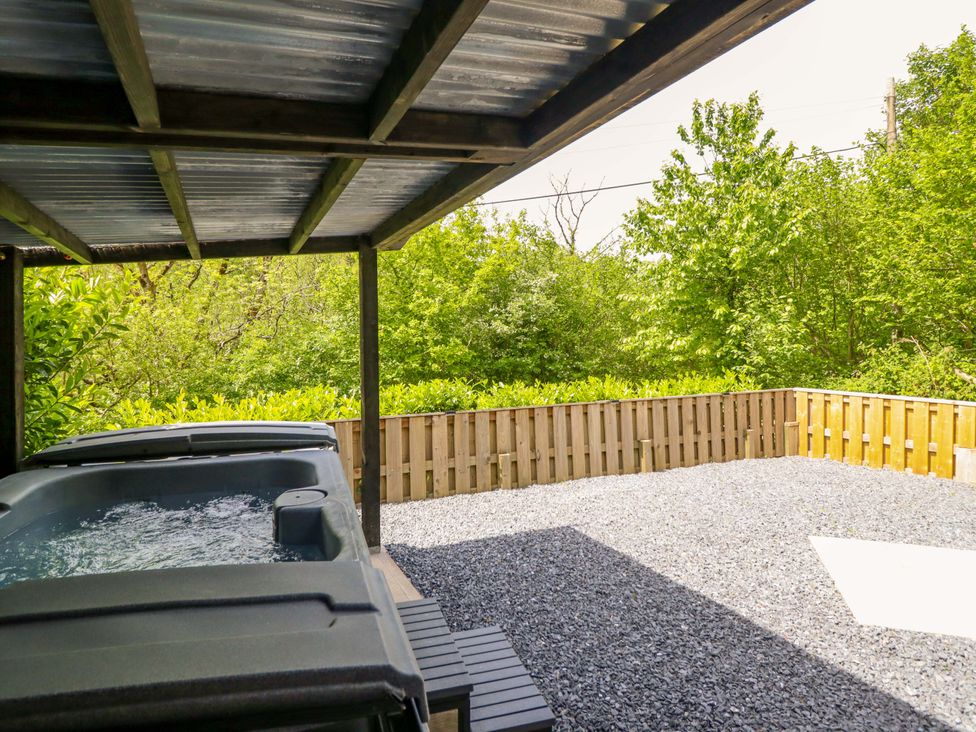 An outdoor area with a jacuzzi and gravel surface at Lodge at Nadur Commins Coch near Machynlleth