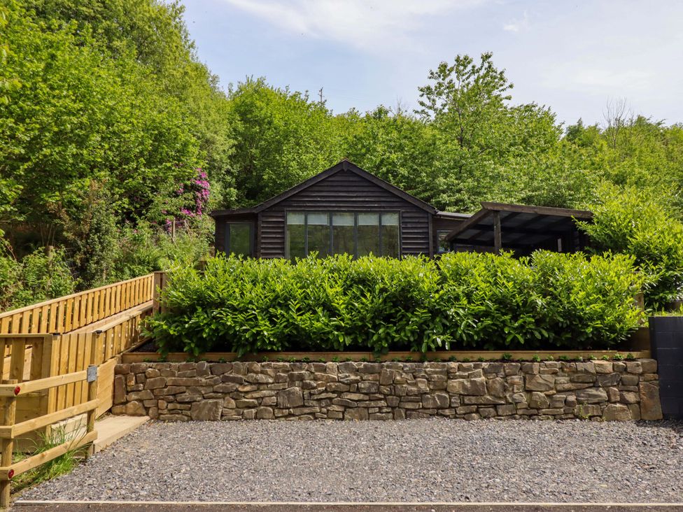 A cabin surrounded by trees and plants at Lodge at Nadur Commins Coch near Machynlleth
