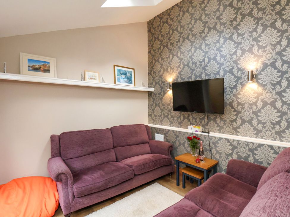 A living room with a sofa and television at Sunnyvale House in Whitby