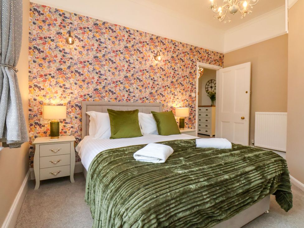 A bedroom with a bed and floral wallpaper at Sunnyvale House in Whitby