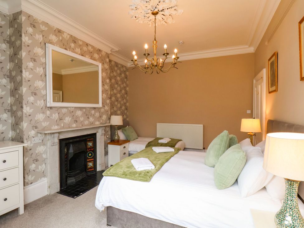 A bedroom with two beds and a fireplace at Sunnyvale House in Whitby