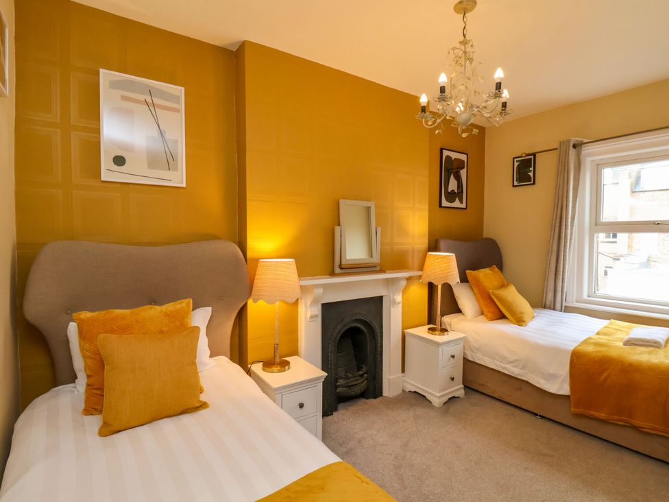 A bedroom with two beds and a fireplace at Sunnyvale House in Whitby