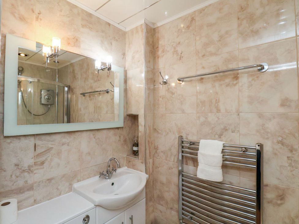 A bathroom with a sink, mirror, and towel rack at Sunnyvale House in Whitby