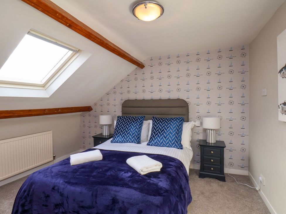 A bedroom with a bed against a decorated wall at Sunnyvale House in Whitby