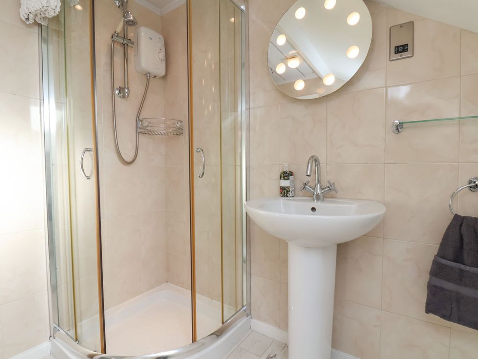 A bathroom with a shower, sink, and mirror at Sunnyvale House in Whitby
