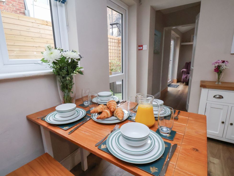 A kitchen table set with plates and croissants at Sunnyvale House in Whitby