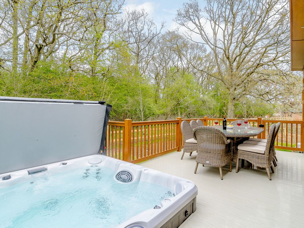 An outdoor space with a hot tub and dining table at The Fotheringhay in Kings Cliffe