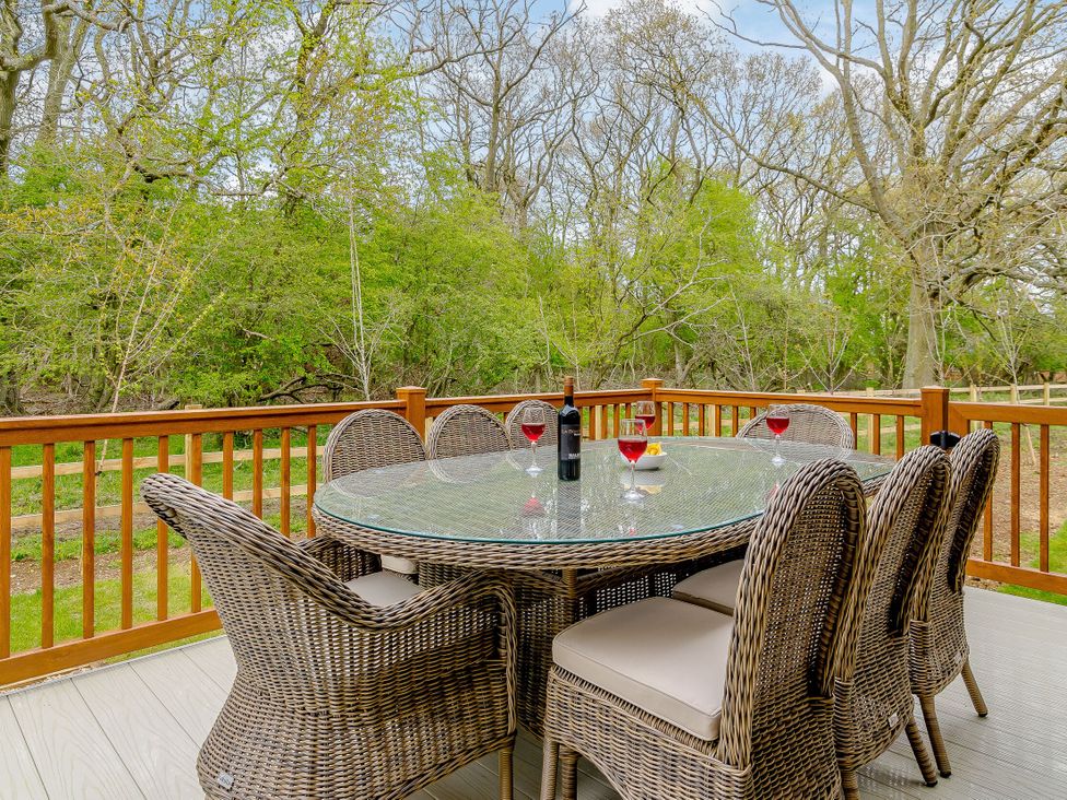An outdoor dining area with a round table and chairs at The Fotheringhay (Pet) in Kings Cliffe