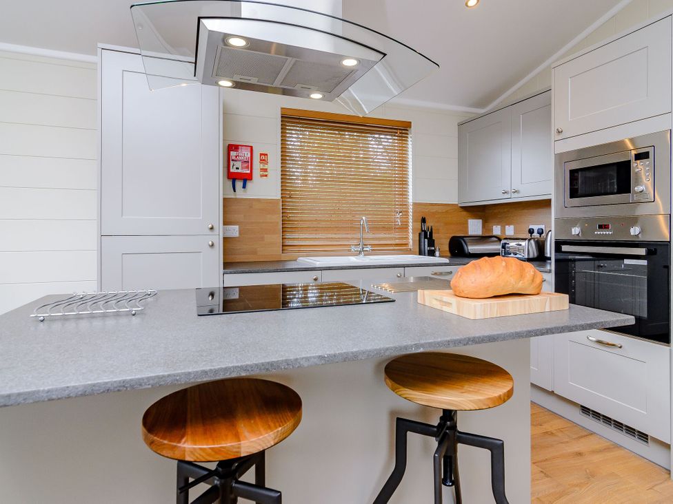 A kitchen with a kitchen island and stools at The Folkesworth (Pet) in Kings Cliffe