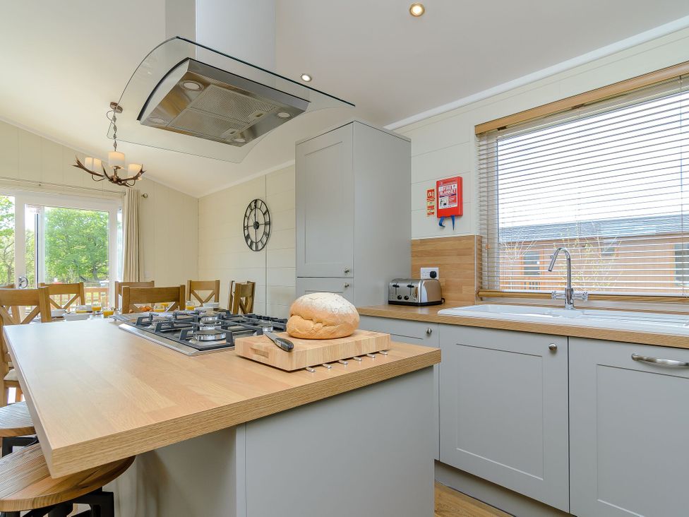 A kitchen with an oven, stove, sink, and bread on a cutting board at The Alwalton (Pet) Kings Cliffe