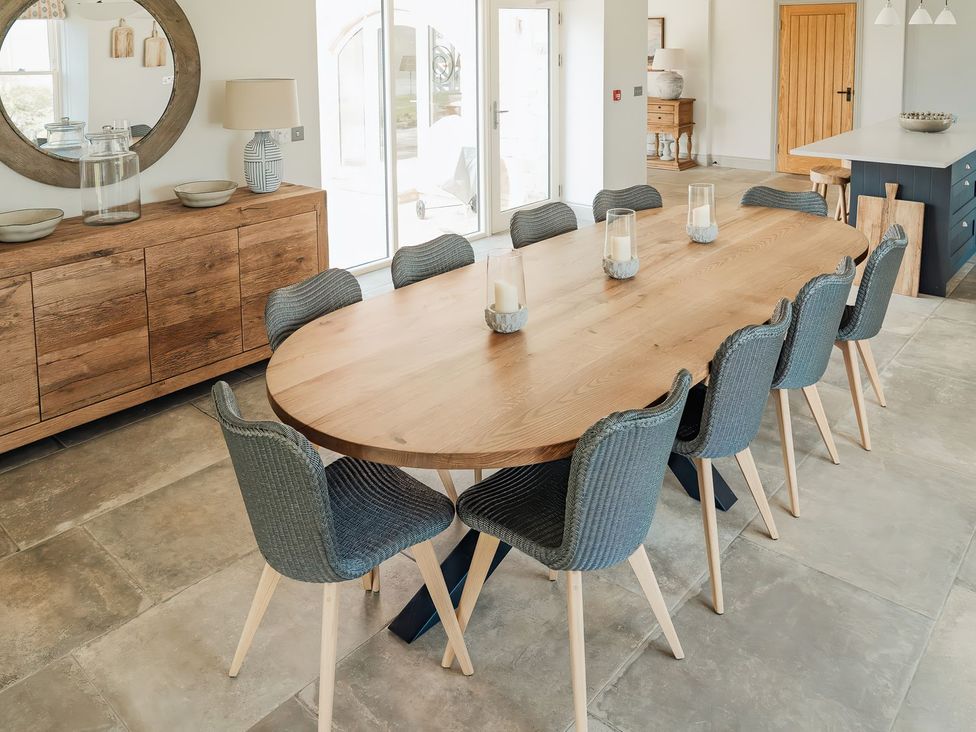 A dining room with a large table and eight chairs at The Old Watermill in Beadnell