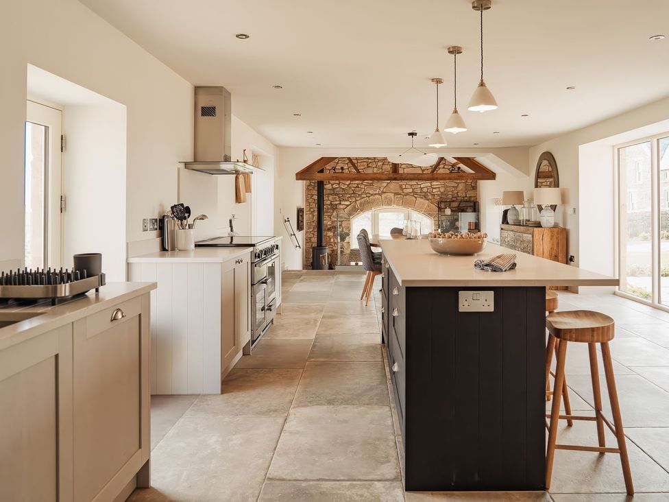 A kitchen with a countertop and bar stools at The Old Watermill in Beadnell