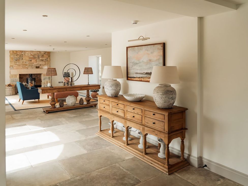 A living room with a console table and lamps at The Old Watermill in Beadnell