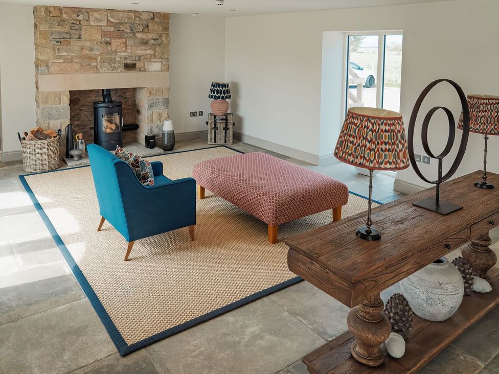 A living room with a fireplace and seating area at The Old Watermill in Beadnell