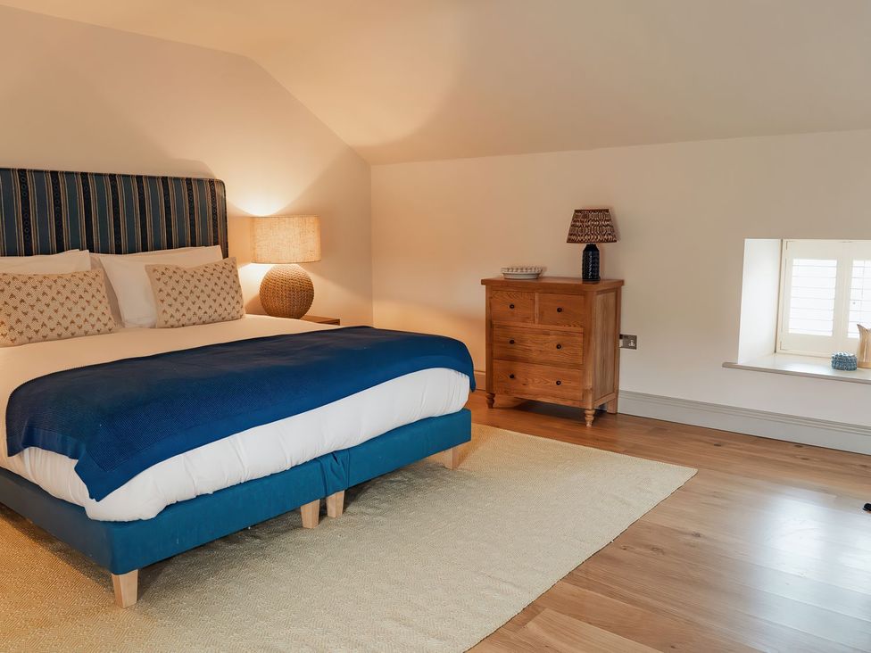 A bedroom with a bed and a chest of drawers at The Old Watermill in Beadnell