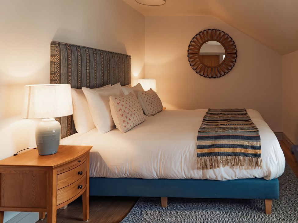A bedroom with a bed and bedside tables at The Old Watermill in Beadnell