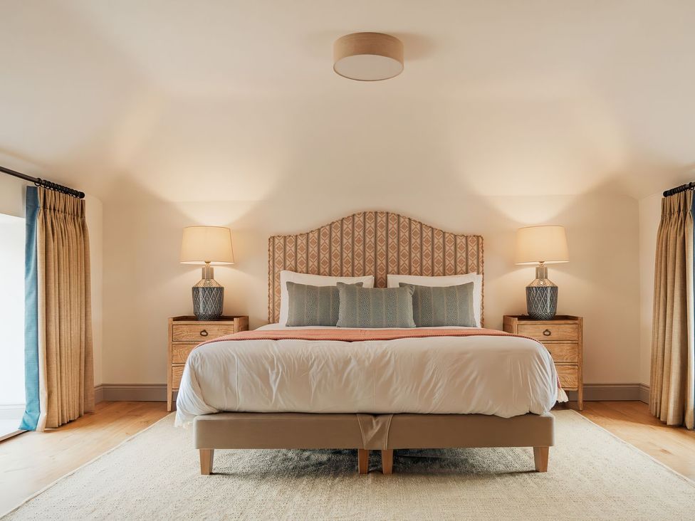 A bedroom with a bed and bedside tables at The Old Watermill in Beadnell