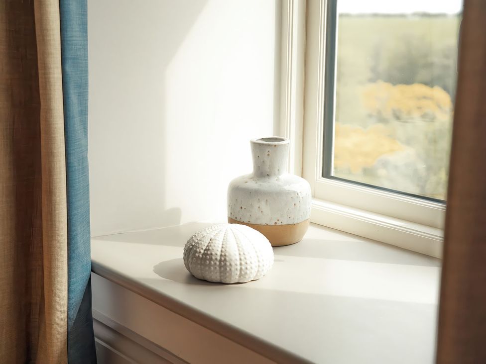 A windowsill with a vase and seashell at The Old Watermill in Beadnell