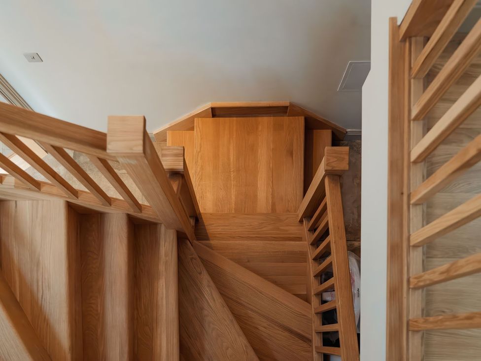 A staircase with wooden steps and railing at The Old Watermill in Beadnell