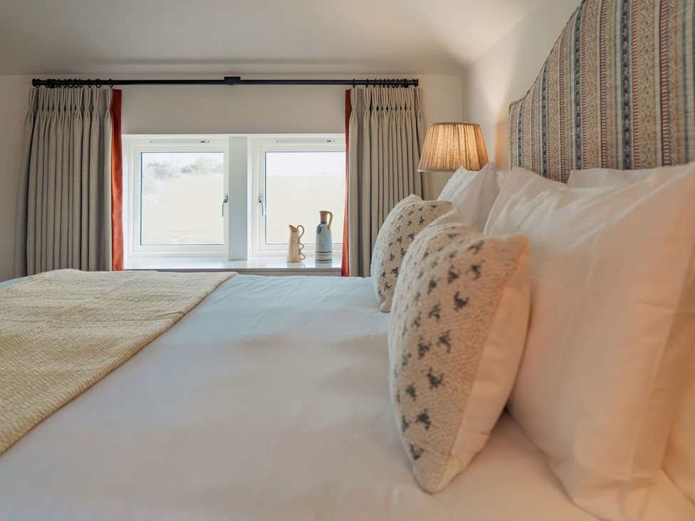 A bedroom with a bed and pillows at The Old Watermill in Beadnell