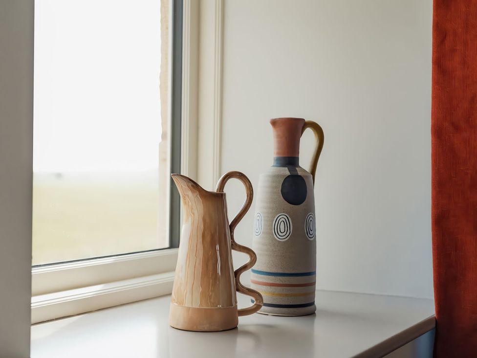 A window sill with decorative jugs at The Old Watermill in Beadnell