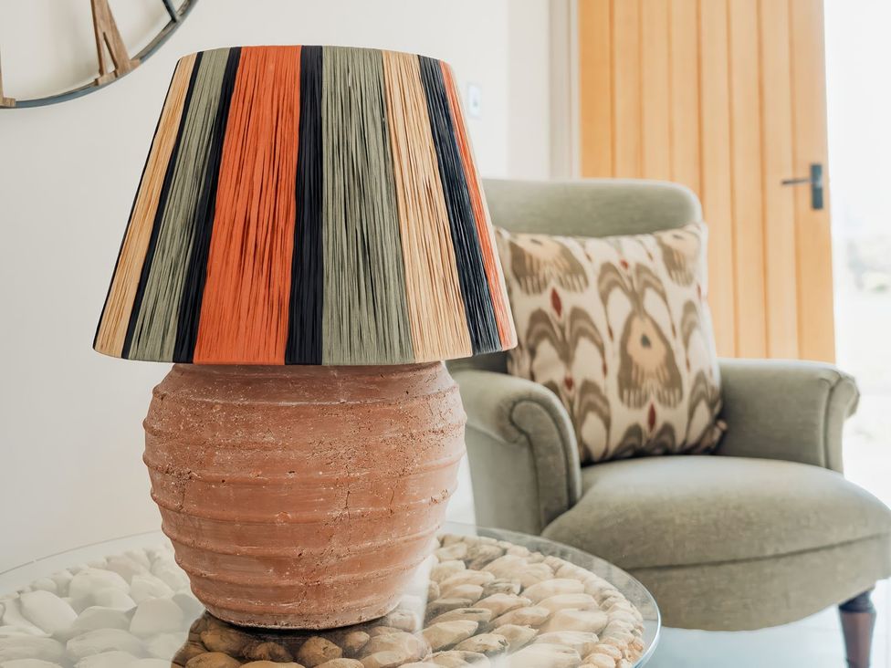 A lamp on a table next to a chair at The Old Watermill in Beadnell