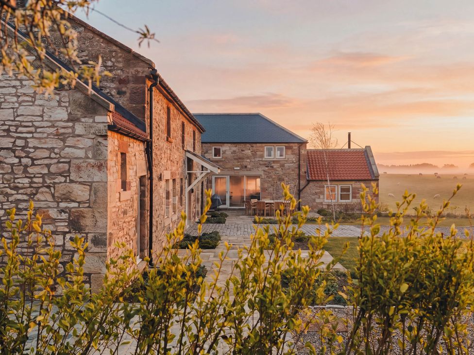 An outdoor seating area and stone houses at The Old Watermill Beadnell