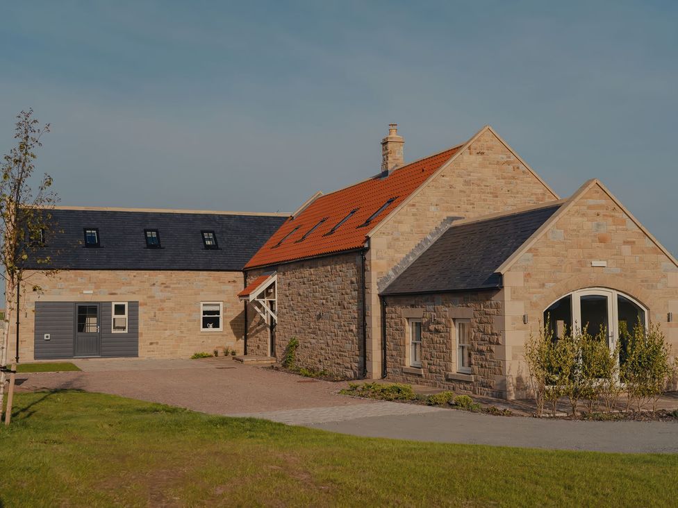 A house with a driveway and garden at Mill Farm House Beadnell