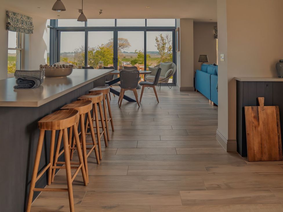 A kitchen with bar stools and a table at Mill Farm House in Beadnell