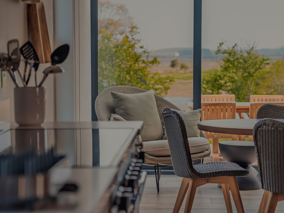A kitchen with utensils and dining furniture at Mill Farm House Beadnell