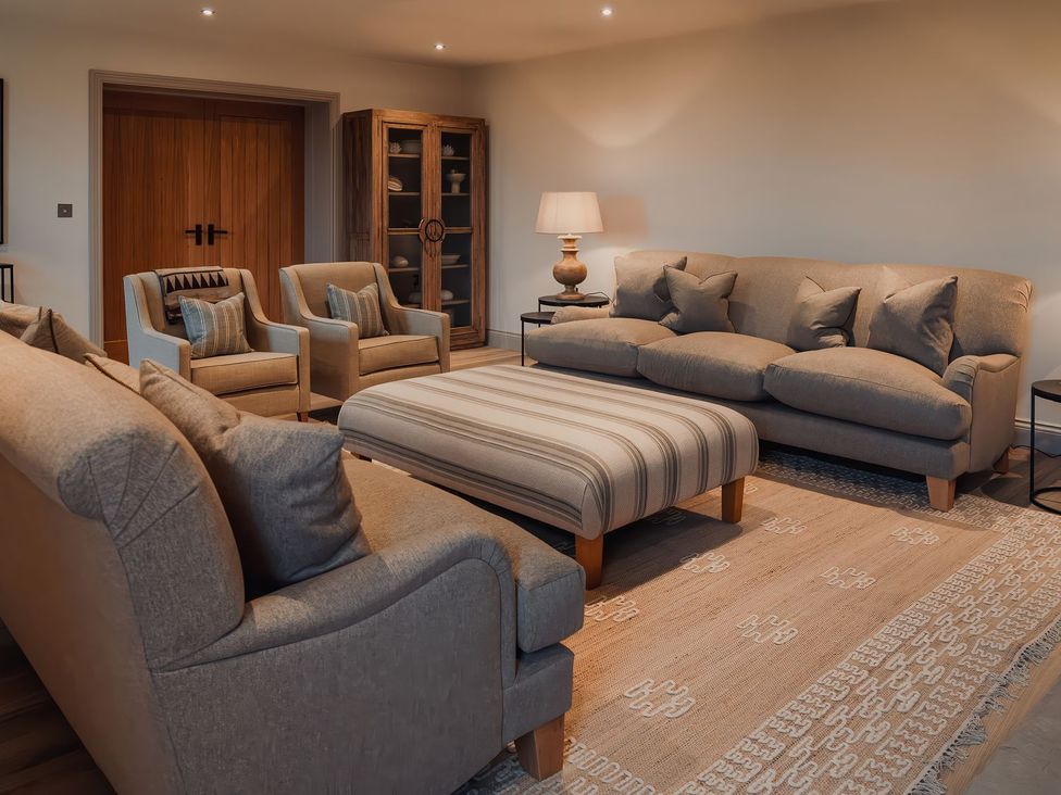 A living room with seating and a lamp at Mill Farm House Beadnell