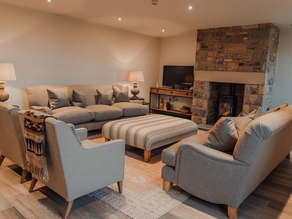 A living room with a sofa and fireplace at Mill Farm House Beadnell