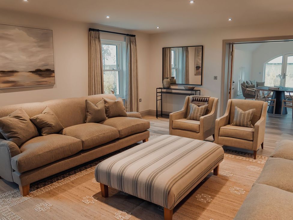 A living room with a sofa and armchairs at Mill Farm House Beadnell