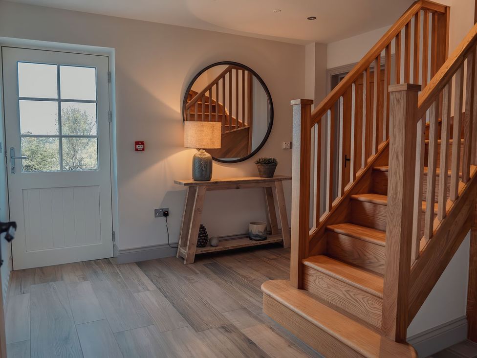 A hallway with stairs and a table at Mill Farm House Beadnell