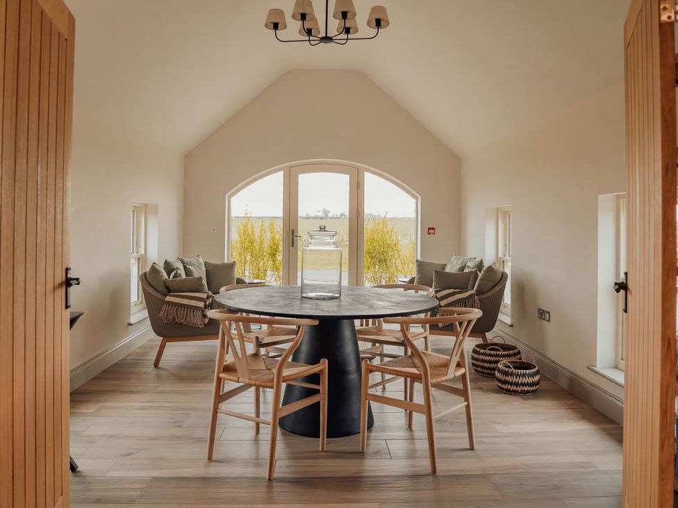 A dining room with a round table and chairs at Mill Farm House Beadnell