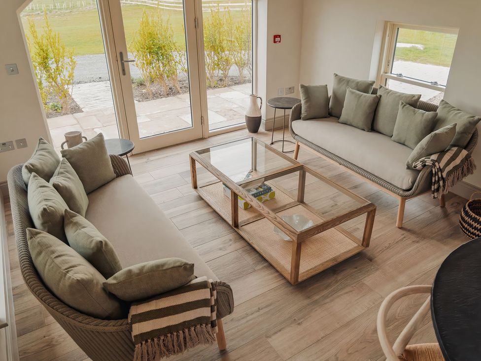 A living room with two sofas and a coffee table at Mill Farm House Beadnell