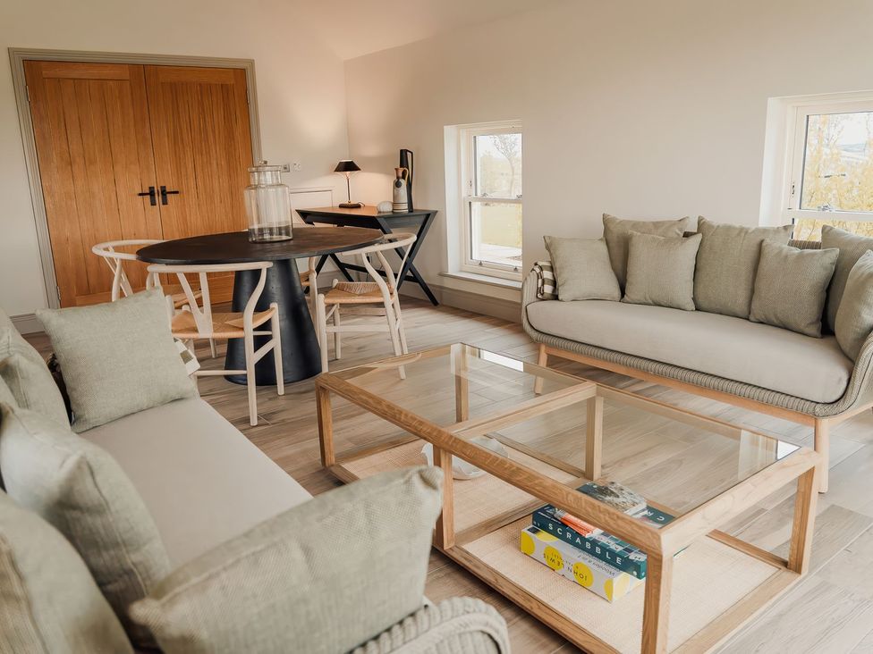 A living room with a sofa and dining table at Mill Farm House Beadnell